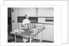 Man Taking Bread Loaves from Oven by Anonymous
