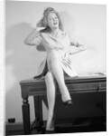 Woman Seated on Desk with Legs Crossed by Anonymous