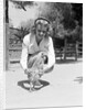 Woman Kneels and Pets Baby Ostrich by Anonymous