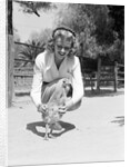 Woman Kneels and Pets Baby Ostrich by Anonymous