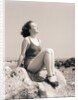 Young Woman Sitting on Beach Rocks by Anonymous