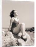 Young Woman Sitting on Beach Rocks by Anonymous