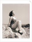 Young Woman Sitting on Beach Rocks by Anonymous