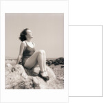 Young Woman Sitting on Beach Rocks by Anonymous