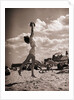Young Woman Playing Ball On Beach by Anonymous
