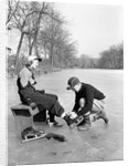 Man Putting on Woman's Ice Skates by Anonymous