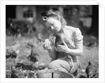 Woman Holds Chicken For Feeding by Anonymous