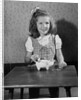 Girl Putting Money In Piggy Bank by Anonymous