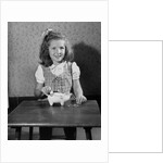 Girl Putting Money In Piggy Bank by Anonymous