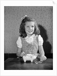 Girl Putting Money In Piggy Bank by Anonymous