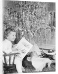 Girl Sitting Beside Christmas Tree by Anonymous