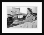 Woman Putting Dishes In Cabinet by Anonymous