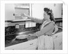 Woman Putting Dishes In Cabinet by Anonymous