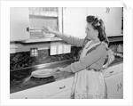 Woman Putting Dishes In Cabinet by Anonymous