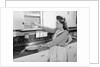Woman Putting Dishes In Cabinet by Anonymous