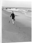 Woman Walking on Beach Leaving Footprints by Anonymous