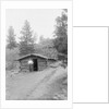 Man Standing in Front of Log Cabin by Anonymous