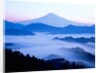 Distant view of Mount Fuji silhouetted against blue sky by Anonymous