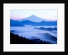 Distant view of Mount Fuji silhouetted against blue sky by Anonymous