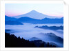 Distant view of Mount Fuji silhouetted against blue sky by Anonymous