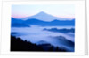 Distant view of Mount Fuji silhouetted against blue sky by Anonymous
