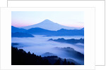 Distant view of Mount Fuji silhouetted against blue sky by Anonymous