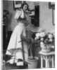 Woman Talking on Wall Mounted Telephone by Anonymous