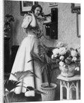 Woman Talking on Wall Mounted Telephone by Anonymous