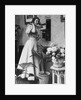 Woman Talking on Wall Mounted Telephone by Anonymous