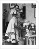 Woman Talking on Wall Mounted Telephone by Anonymous