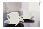 Two coffee cups on a table by Anonymous
