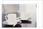 Two coffee cups on a table by Anonymous