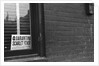 Sign Posted in Window of Building by Anonymous