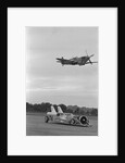 Airplane Flying Over Race Car in Action by Anonymous