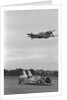 Airplane Flying Over Race Car in Action by Anonymous