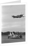 Airplane Flying Over Race Car in Action by Anonymous