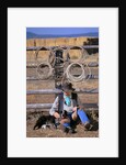 Cowboy and Dog Sitting Against Fence by Anonymous