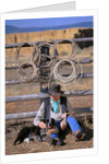 Cowboy and Dog Sitting Against Fence by Anonymous