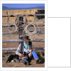 Cowboy and Dog Sitting Against Fence by Anonymous