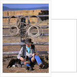 Cowboy and Dog Sitting Against Fence by Anonymous