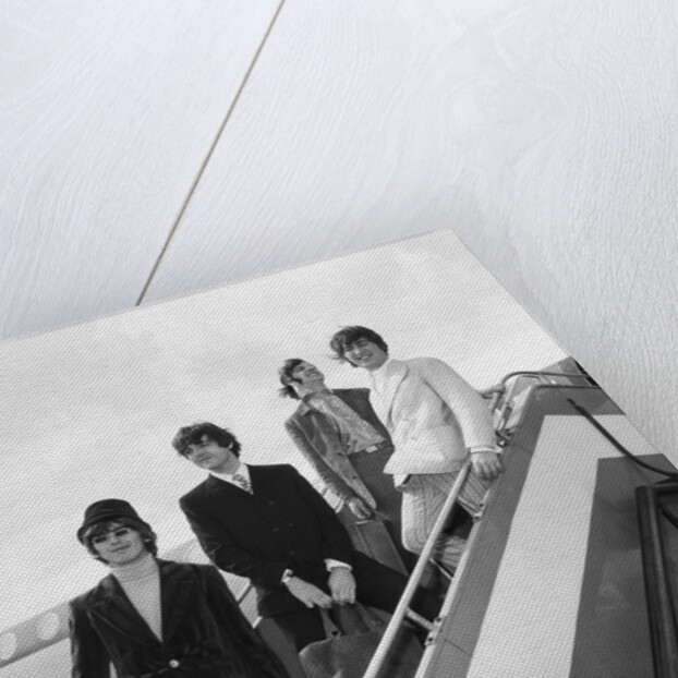 The Beatles on the steps of a plane by Associated Newspapers