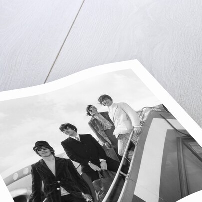 The Beatles on the steps of a plane by Associated Newspapers