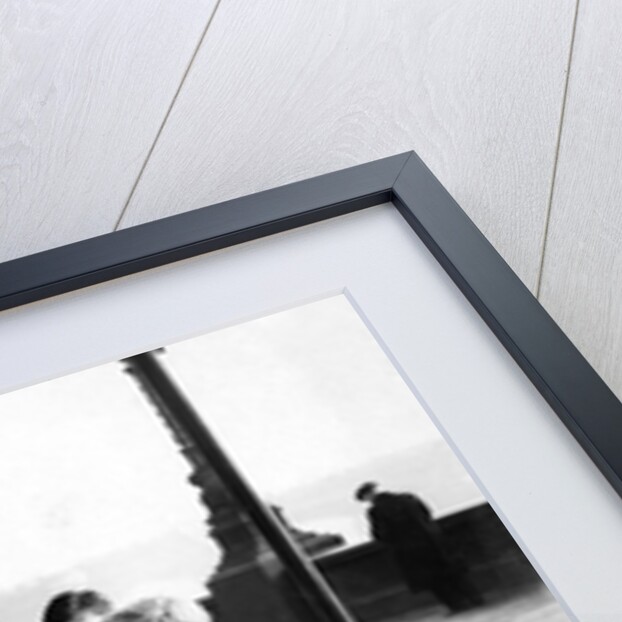 Boys on bicycles cross in front of a tram by Associated Newspapers