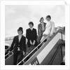 The Beatles on the steps of a plane by Associated Newspapers