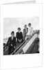 The Beatles on the steps of a plane by Associated Newspapers