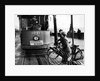 Boys on bicycles cross in front of a tram by Associated Newspapers