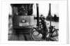 Boys on bicycles cross in front of a tram by Associated Newspapers