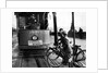 Boys on bicycles cross in front of a tram by Associated Newspapers