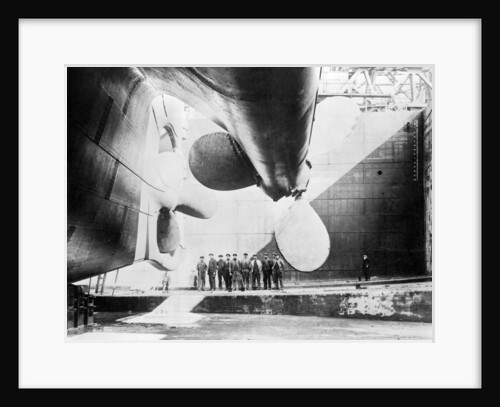 Workmen standing under one of the propellors of the Titanic, 31 May, 1911 by Anonymous
