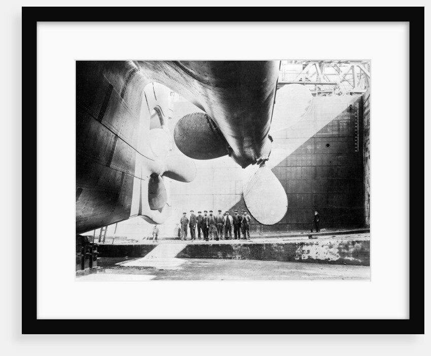 Workmen standing under one of the propellors of the Titanic, 31 May, 1911 by Anonymous
